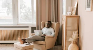 smiling man on couch with laptop