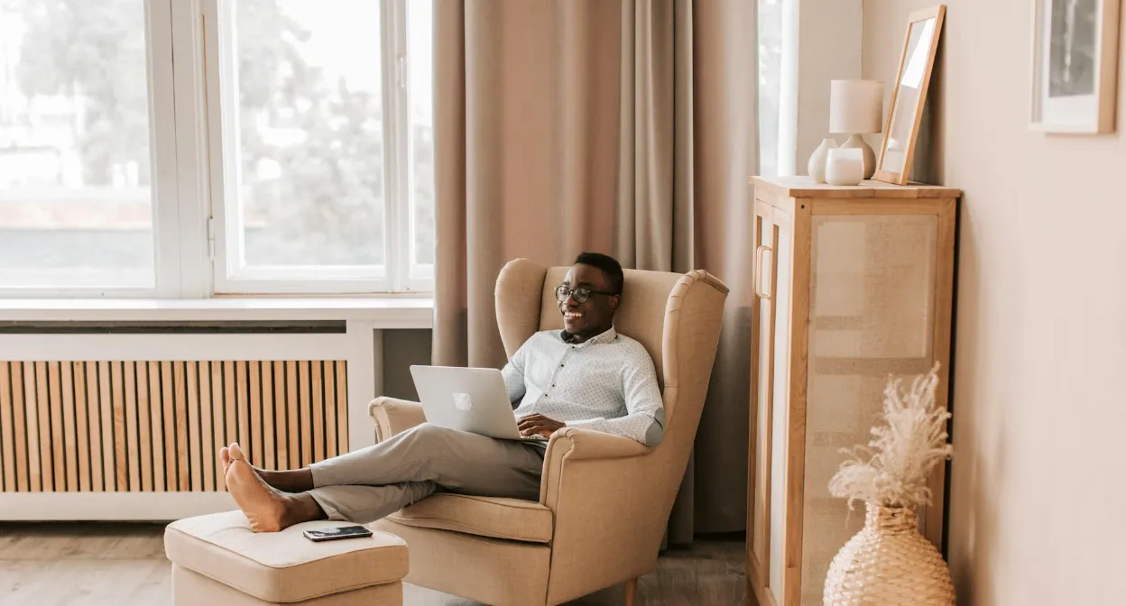 smiling man on couch with laptop